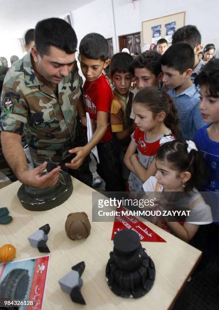 Lebanese soldier explains to children about the various types of mines during a mine awareness campaign before the start of the new school year in...