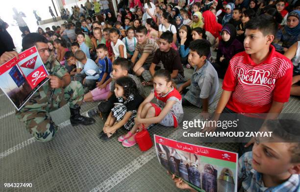 Lebanese soldier explains to children during an awareness campaign about mines before the start of the new school year in the southern village of...