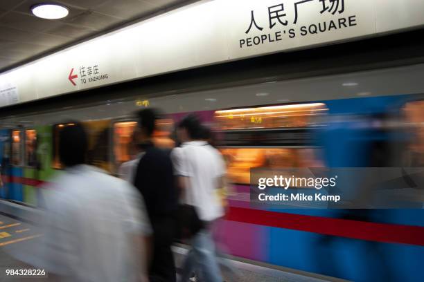 Commuters wait on the platform for a train at People's Square Metro station in Shanghai, China. The Shanghai Metro system is cheap, clean and...