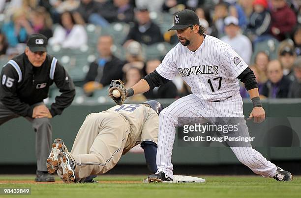 First baseman Todd Helton of the Colorado Rockies takes a pick off throw at first base to hold Tony Gwynn Jr. #18 of the San Diego Padres as umpire...