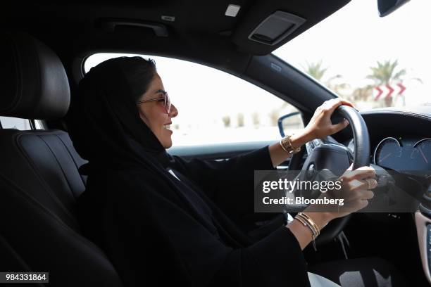 Saudi woman drives an automobile along a highway after obtaining her official driving licence in Riyadh, Saudi Arabia, on Monday, June 25, 2018....