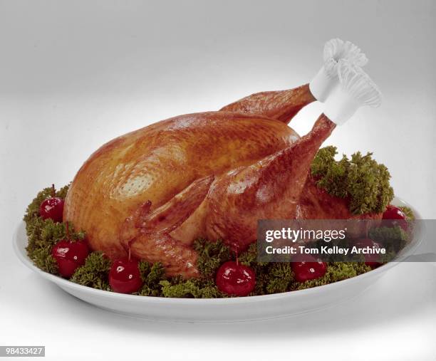 View of a cooked turkey, garnished with lettue and crabapples on a serving platter, 1966.