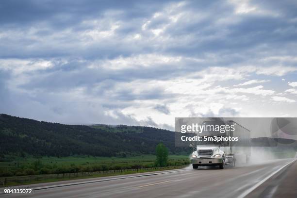white 18 wheeler tractor trailer truck on mountain road - eld stock-fotos und bilder