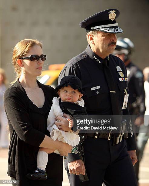 Emily Cottle carries her nine-month-old daughter and is accompanied by Los Angeles Police Chief Charlie Beck during the funeral of her husband Robert...