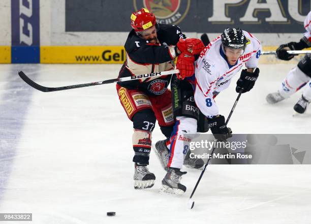Tino Boos of Hannover and Dominik Walsh of Ingolstadt battle for the puck during the third DEL play off semi final match between Hannover Scorpions...