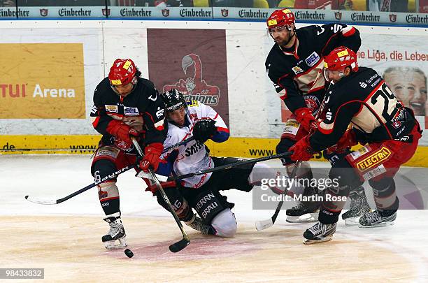 Tino Boos of Hannover and Dominik Walsh of Ingolstadt battle for the puck during the third DEL play off semi final match between Hannover Scorpions...