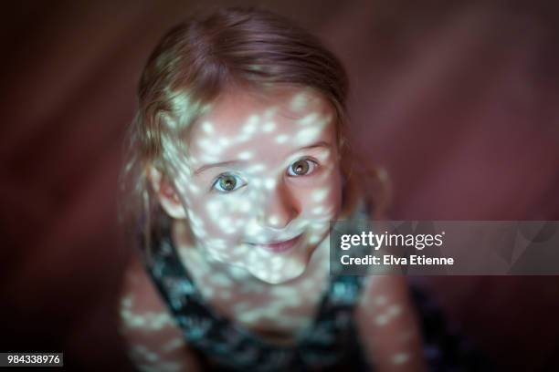 girl (4-5) with multiple reflections of green scattered light falling across her face - sparkle children stock pictures, royalty-free photos & images