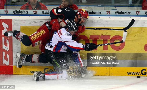 Tino Boos of Hannover and Dominik Walsh of Ingolstadt battle for the puck during the third DEL play off semi final match between Hannover Scorpions...