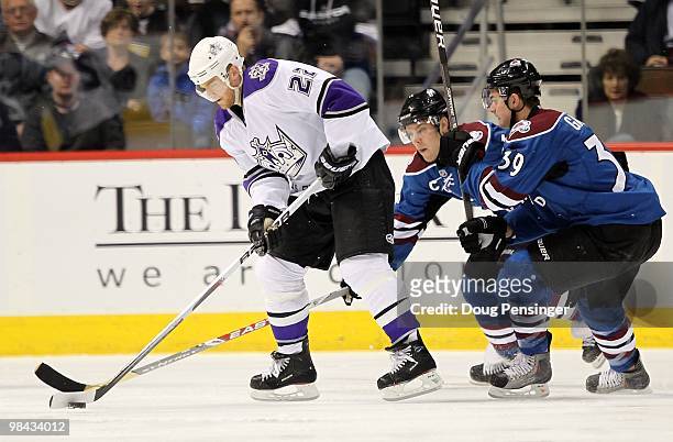 Jeff Halpern of the Los Angeles Kings controls the puck against Paul Stastny and TJ Galiadi of the Colorado Avalanche during NHL action at the Pepsi...