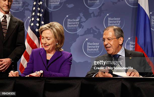 Secretary of State Hillary Rodham Clinton and Russian Foreign Minister Sergey Lavrov sign copies of an agreement on eliminating excess weapon-grade...