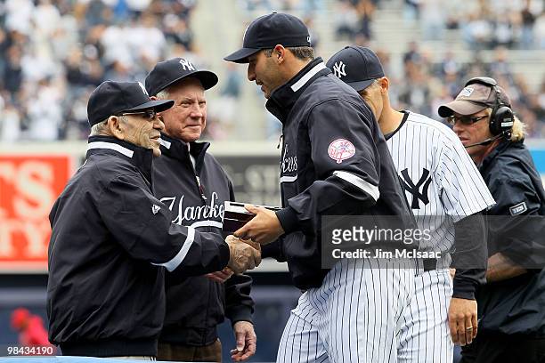 Andy Pettitte of the New York Yankees greets Yankee's legends and Baseball Hall of Famers Yogi Berra and Whitey Ford as Pettitte receives his 2009...