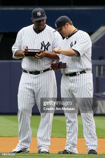 Sabathia and Joba Chamberlain of the New York Yankees look at their 2009 World Series rings after they received them prior to playing against the Los...