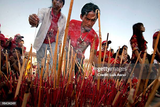 Anti-government 'Red Shirt' protesters offer prayers near a memorial site for the victims of the fierce street battles between protesters and the...