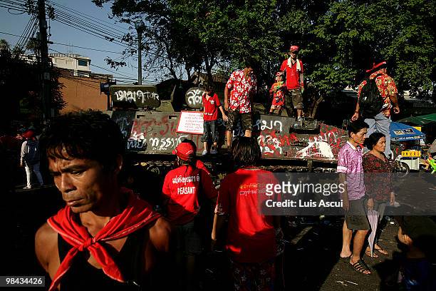 Anti-government 'Red Shirt' protesters walk around abandoned army vehicles during the Songkran festival, marking the Thai new year, near the...