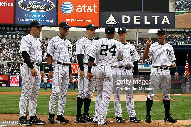 Robinson Cano of the New York Yankees is greeted by manager Joe Girardi, Derek Jeter, Nick Johnson, Mark Teixeira and Alex Rodriguez during player...