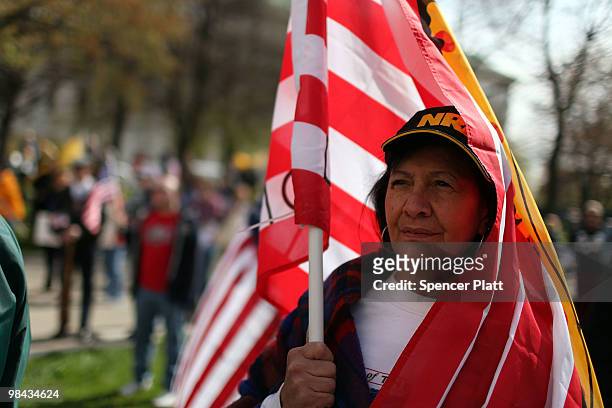 Corinne Peretin holds an American flag at a Tea Party Express rally on April 13, 2010 in Albany, New York. The Tea Party Express will head to Boston...