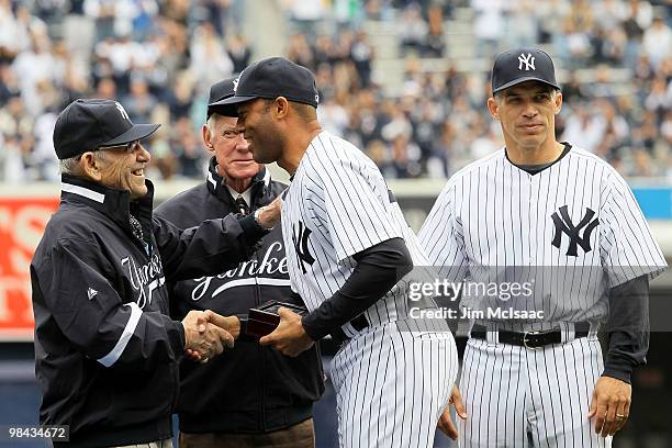 Mariano Rivera of the New York Yankees greets Yankee's legends and Baseball Hall of Famers Yogi Berra and Whitey Ford as Rivera receives his 2009...