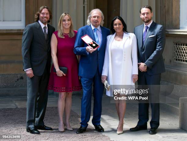 Singer and songwriter Barry Gibb, with his wife, Linda and children, Michael , Alexandra and Ashley at Buckingham Palace, London, after he was...