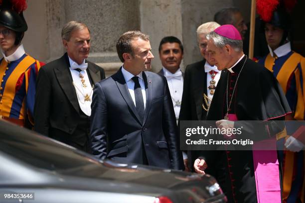 French President Emmanuel Macron, flanked by Prefect of the Pontifical House Georg Ganswein , leaves the Apostolic Palace at the end of an audience...