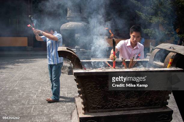 Shanghainese people burn incense during daily prayer sessions at the Longhua Temple in the south of Shanghai, China. This is a working Buddhist...