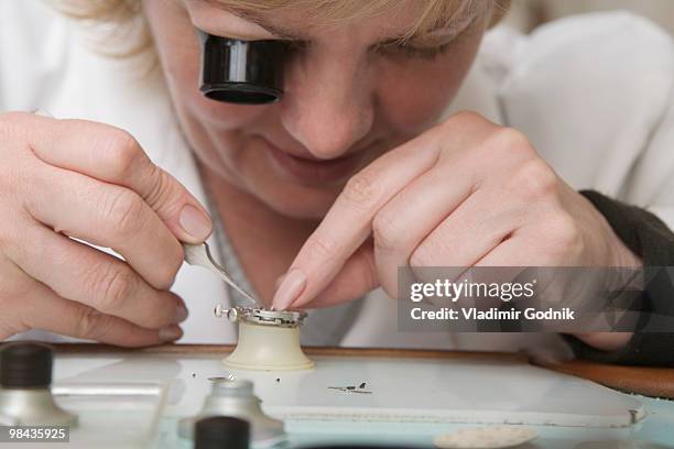 portrait of female watchmaker at work - uhrmacher stock-fotos und bilder