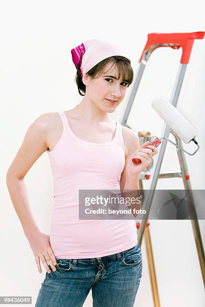 portrait of teenage girl holding paint roller - fotohandy stock pictures, royalty-free photos & images