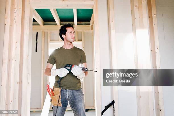 full body portrait of young man standing in door of house under construction - man standing full body stock pictures, royalty-free photos & images