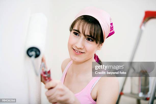 teenage girl decorating walls of her new home - fotohandy stock pictures, royalty-free photos & images