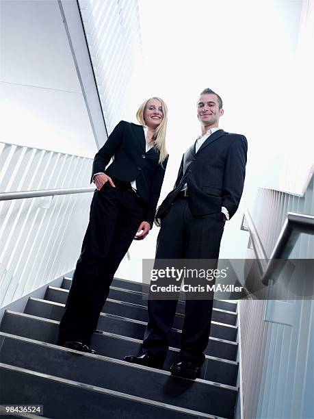 full body portrait of young businessman and man standing in staircase - man standing full body photos et images de collection