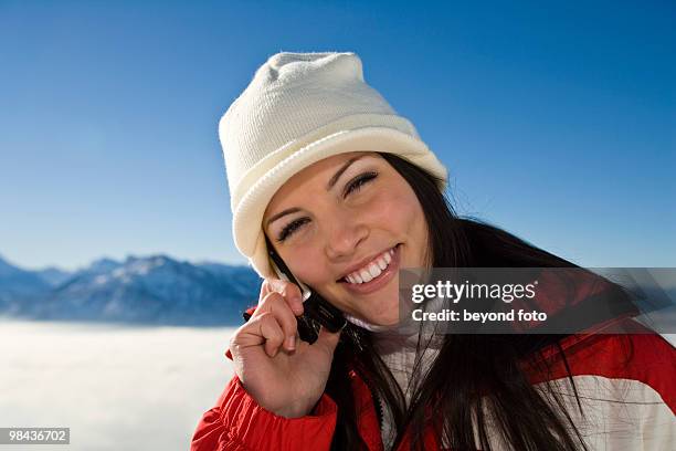 portrait of young woman in the mountains talking on mobile phone - fotohandy stock pictures, royalty-free photos & images