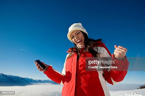 portrait of joyous woman with mobile phone in the mountains - fotohandy stock pictures, royalty-free photos & images