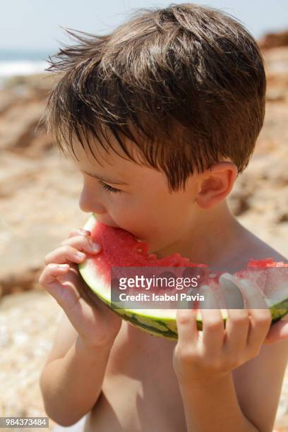 boy eating a slice of watermelon - isabel pavia stock-fotos und bilder