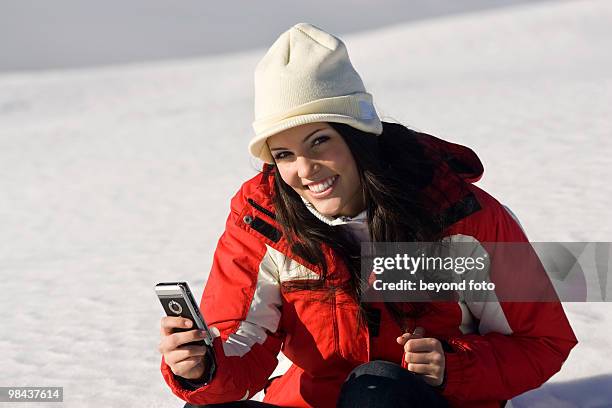 young woman in the mountains checking her mobile phone for text messages - fotohandy stock pictures, royalty-free photos & images