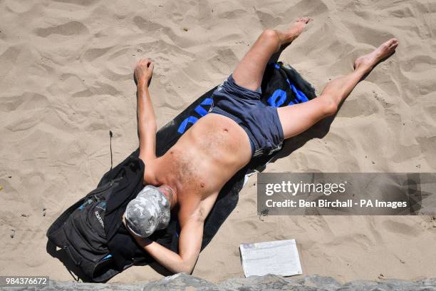 Man relaxes on the beach at Barry Island, Vale of Glamorgan, Wales, as temperatures are predicted to increase this week.