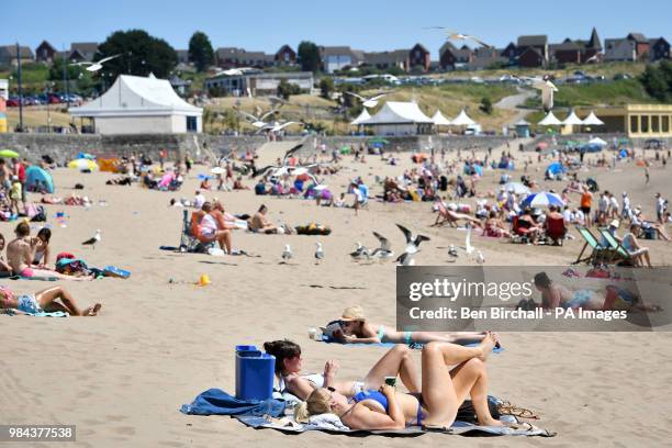 People relax on the beach at Barry Island, Vale of Glamorgan, Wales, as temperatures are predicted to increase this week.