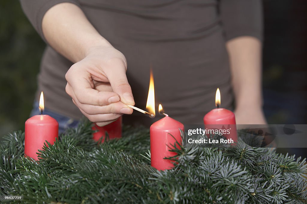 Detail of woman lighting advent wreath