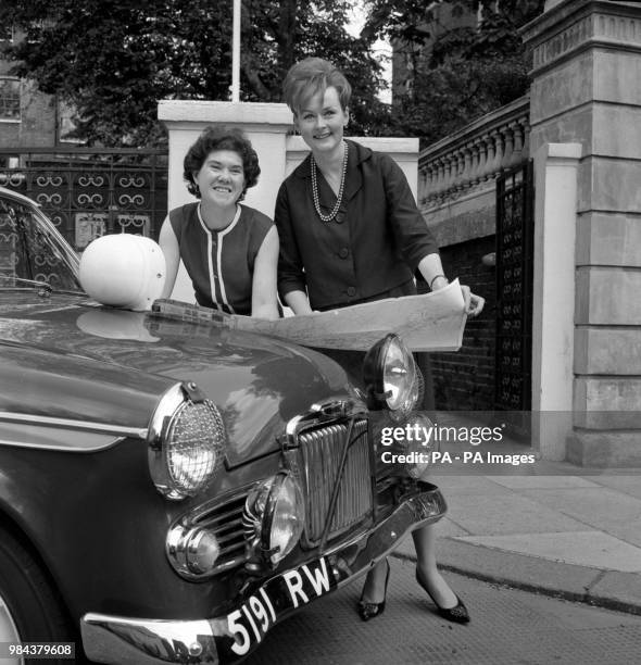 Dublin-born Rosemary Smith and Rosemary Sears use the bonnet of their Sunbeam Rapier to study maps of the route they will take as the Rootes Group...