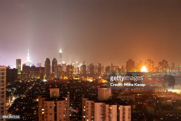 The Oriental Pearl Tower and Jin Mao Building rise up, glowing in the distance in Pudong, and Chinas centralised financial district in Shanghai,...