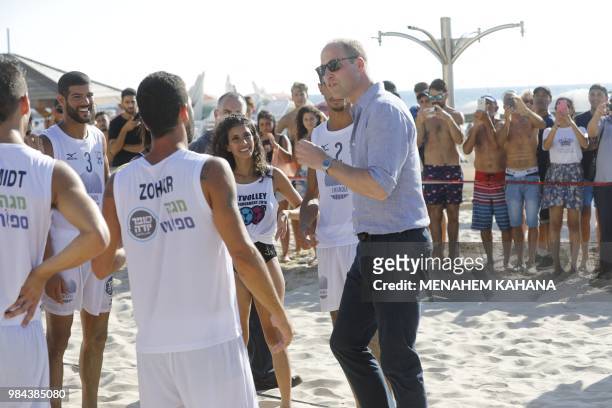 Britain's Prince William speaks to beach volleyball players during a visit with the mayor of Tel Aviv to a beach in the coastal Israeli Mediterranean...