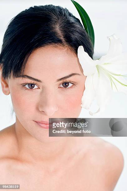 portrait of young woman with flower in her hair - studiofoto stock pictures, royalty-free photos & images