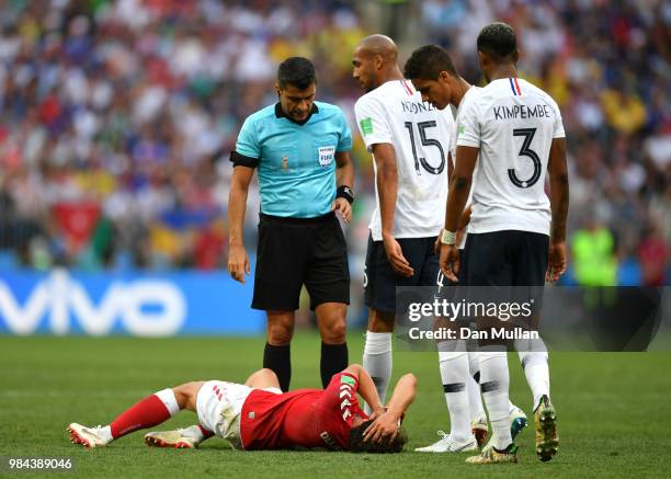 Thomas Delaney of Denmark lies on the pitch while Referee Sandro Ricci, Steven Nzonzi, Raphael Varane and Presnel Kimpembe of France check his...