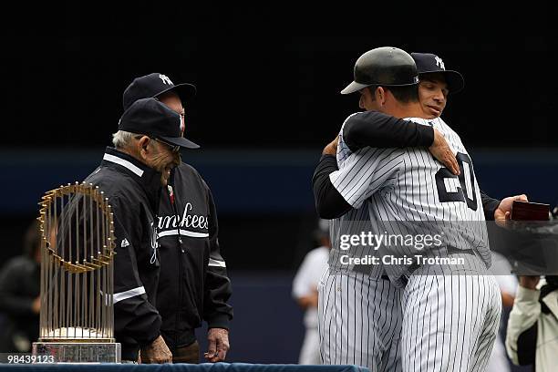 Manager Joe Girardi hugs Jorge Posada of the New York Yankees after presenting him with his World Series ring for being a member of the 2009 New York...