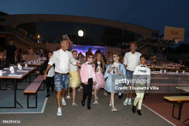 Fashion designers, founders and owners of Dsquared2 Dan Caten and Dean Caten pose with models at the Caten Hight School Prom DSquared2 as a part of...