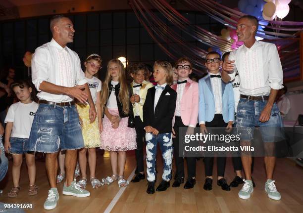 Fashion designers, founders and owners of Dsquared2 Dan Caten and Dean Caten pose with models at the Caten Hight School Prom DSquared2 as a part of...