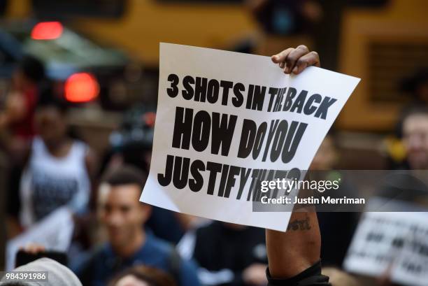 Demonstrator holds up a sign during a protest a day after the funeral of Antwon Rose II on June 26, 2018 in Pittsburgh, Pennsylvania. Rose was killed...