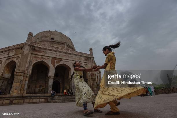 Children play in the compound of Adham Khan's Tomb in Mehrauli, as dark clouds hover over the city, on June 26, 2018 in New Delhi, India. Temperature...