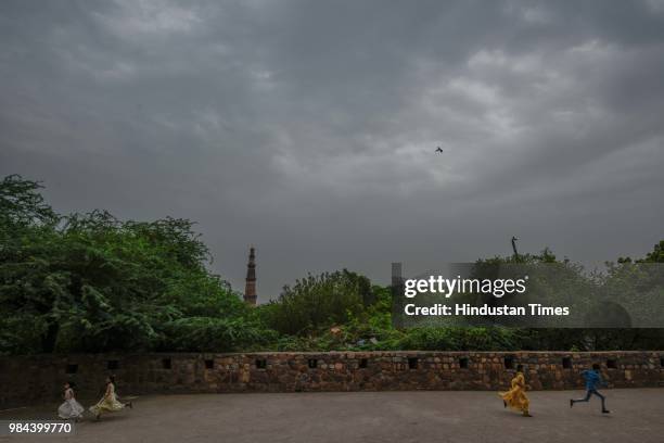 Children play in the compound of Adham Khan's Tomb in Mehrauli, as dark clouds hover over the city, on June 26, 2018 in New Delhi, India. Temperature...