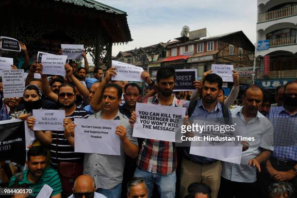 Journalists hold placards during a protest against the assassination of veteran journalist and Editor-in-Chief of Daily Rising Kashmir Syed Shujaat...