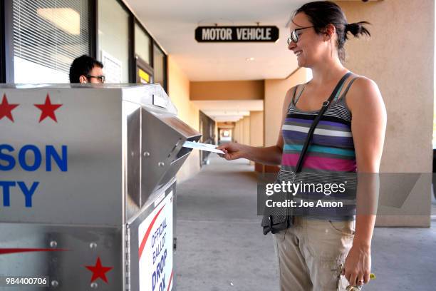 Xandra Coombs of Arvada dropping off her ballot at the Jefferson County DMV June 26, 2018 in Arvada, Colorado.