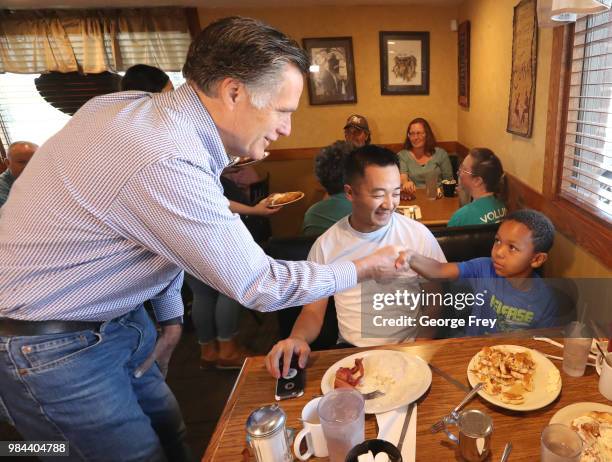 Republican U.S Senate candidate Mitt Romney greets a child at Sills Cafe for a campaign stop on June 26, 2018 in Layton, Utah. It is primary election...